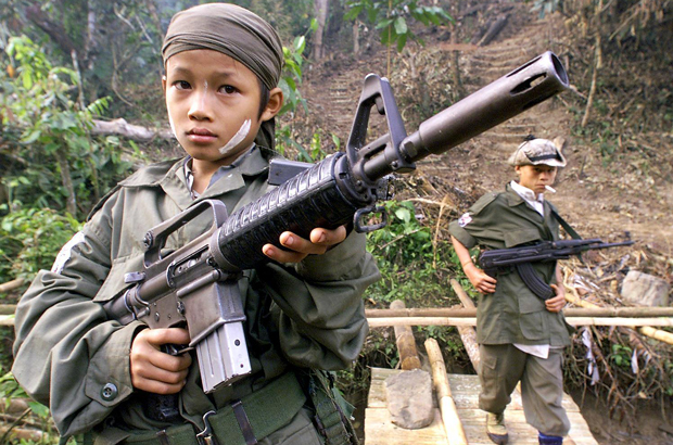 Myanmar, Birmânia, história, violência, rohingya, refugiados, muçulmanos - Crianças do exército insurgente da União Nacional Karen carregam armas de assalto durante comemorações que marcaram o 51º aniversário da rebelião da milícia contra a Junta de Myanmar, em Tak, perto da fronteira com a Tailândia, em 31 de janeiro de 2000 (Pornchai Kittiwongsakul/AFP/Getty Images)