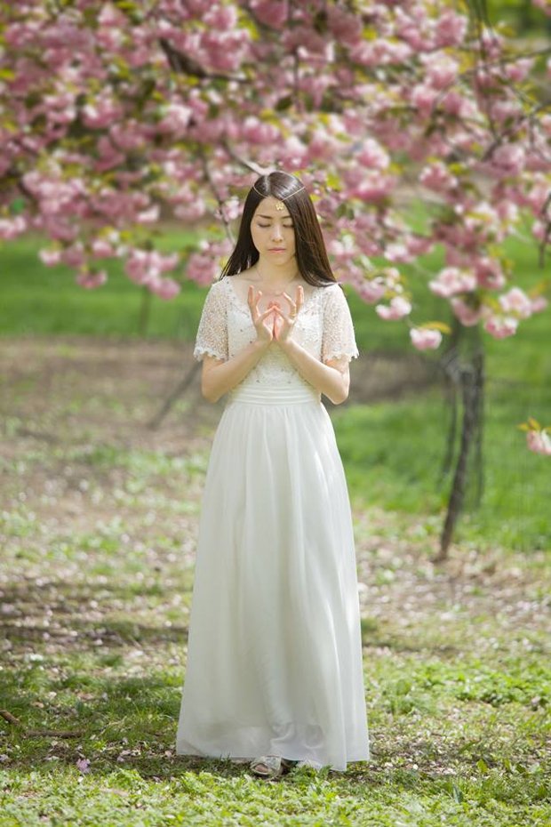A joalheira Ariel Tien fazendo o sinal de mãos de flor de lótus, uma das posições que compõem os exercícios de sua prática tradicional chinesa de meditação (Benny Zhang Studio)