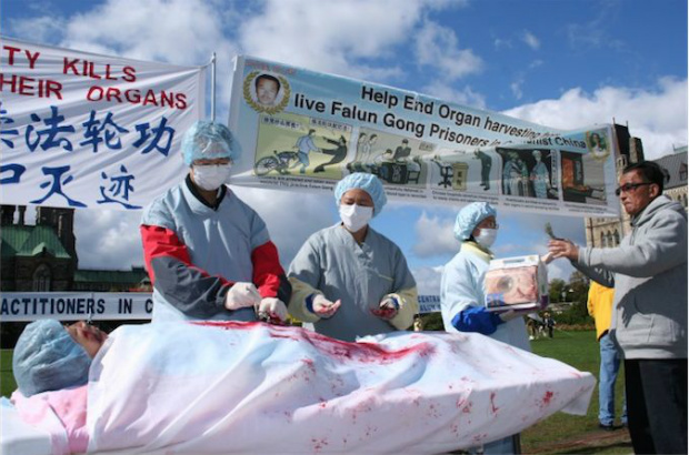 Praticantes do Falun Gong em Ottowa, no Canadá, fazem uma encenação, durante protesto em 2008, da terrível prática de retirada forçada de órgãos. Investigadores dizem que o regime chinês utiliza hospitais militares para a prática de remover os órgãos de praticantes do Falun Gong, grupo perseguido na China, para vendê-los a estrangeiros que precisam de transplante (Epoch Times)